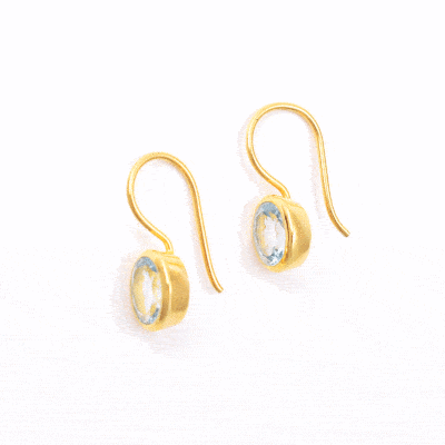 Handmade earrings made of natural, faceted blue topaz gemstones in an oval shape and gold plated sterling silver. Buy online shop.