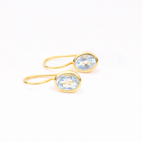 Handmade earrings made of natural, faceted blue topaz gemstones in an oval shape and gold plated sterling silver. Buy online shop.