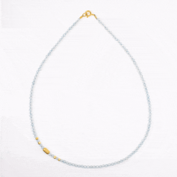 Handmade necklace with natural, faceted blue topaz gemstones in a spherical shape and decorative gold plated sterling silver elements.