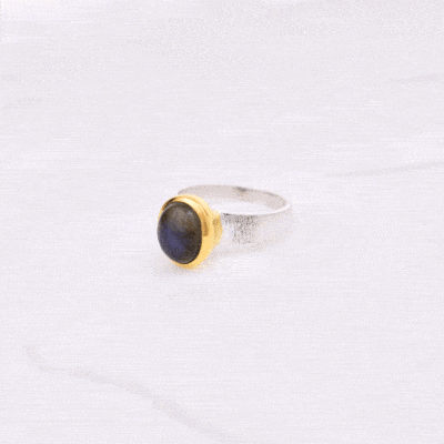 Handmade sterling silver ring with natural, oval shaped labradorite gemstone. The ring has textured band and gold plated bezel. 