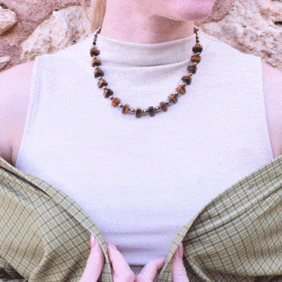 Handmade necklace made of natural, spherical and grommet shaped tiger's eye and pyrite gemstones. The necklace has a gold plated sterling silver clasp. 