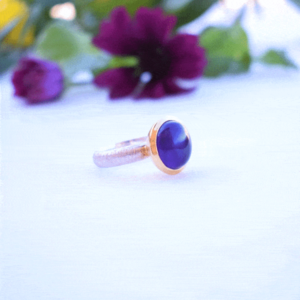 Handmade ring made of sterling silver with natural amethyst stone in a round shape. The ring features a textured band and gold-plated bezel setting