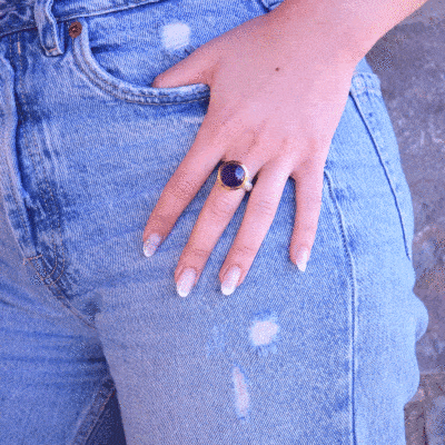 Handmade ring made of sterling silver with natural amethyst stone in a round shape. The ring features a textured band and gold-plated bezel setting