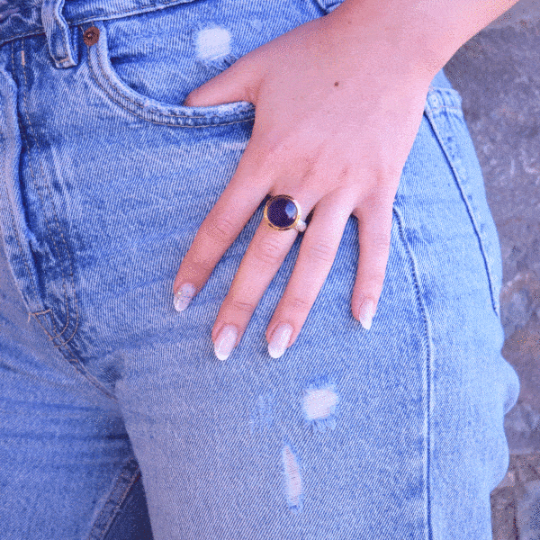 Handmade ring made of sterling silver with natural amethyst stone in a round shape. The ring features a textured band and gold-plated bezel setting