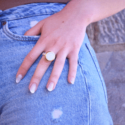 Handmade ring made of sterling silver with natural whithe labradorite gemstone in a round shape. The ring features a textured band and gold-plated bezel setting for a unique, luxurious finish.